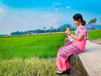 Full length of woman sitting on field