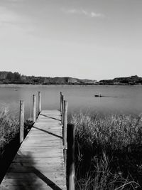 Wooden pier on lake against sky