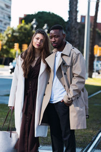 Portrait of young couple standing in city