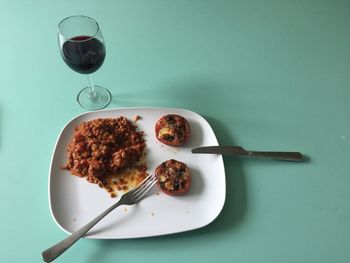 High angle view of food and red wine on table