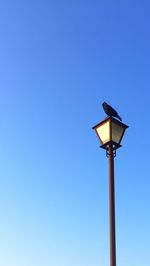 Low angle view of windmill against clear blue sky
