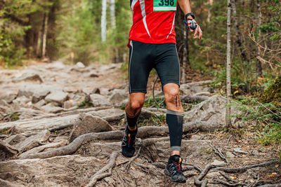 Male runner run forest marathon. blood on knee after injury