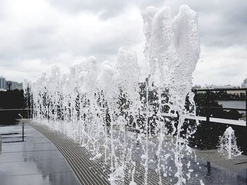 Water fountain in swimming pool against sky