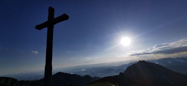 Low angle view of silhouette cross against sky