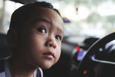 Close-up portrait of cute boy in car