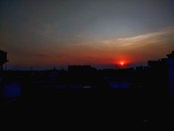 Silhouette buildings against sky during sunset