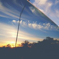 Low angle view of trees against cloudy sky