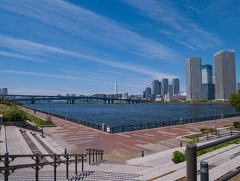 Scenic view of river by buildings against blue sky