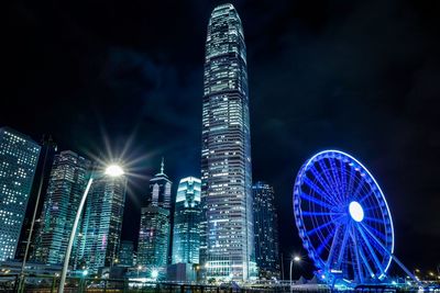 Illuminated hong kong observation wheel in city at night