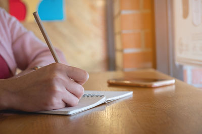 Close-up of man using mobile phone on table