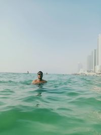 Portrait of man swimming in sea against clear sky