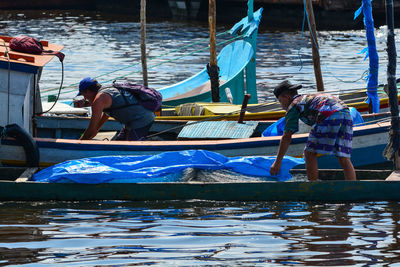 People sitting on boat in lake