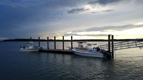 Boats sailing on sea against sky during sunset