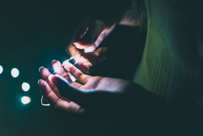 Midsection of woman holding illuminated hands