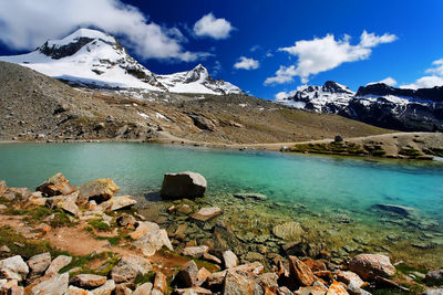 Scenic view of snowcapped mountains by river