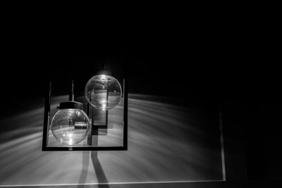 Close-up of illuminated light bulb hanging from ceiling