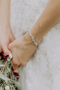 Midsection of bride holding bouquet