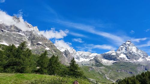 Scenic view of snowcapped mountains against blue sky