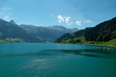 Scenic view of lake by mountains against sky