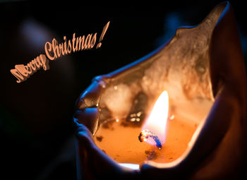 Close-up of hand holding candle