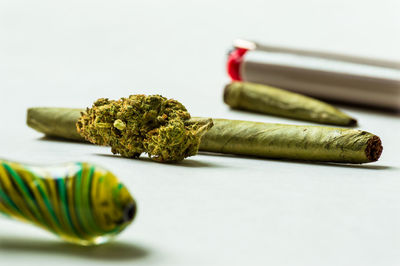 Close-up of cigarette on table against white background