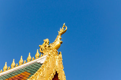 Low angle view of statue against blue sky