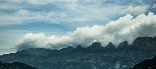 Scenic view of mountains against cloudy sky