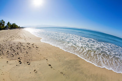 Scenic view of beach against clear blue sky