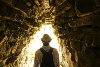 Rear view of man standing in cave