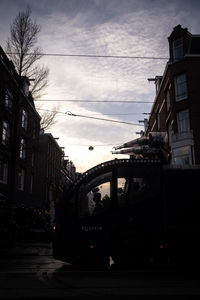 Street and buildings against sky at sunset