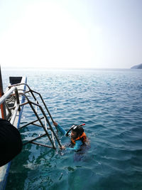 Side view of girl wearing life jacket while swimming in sea