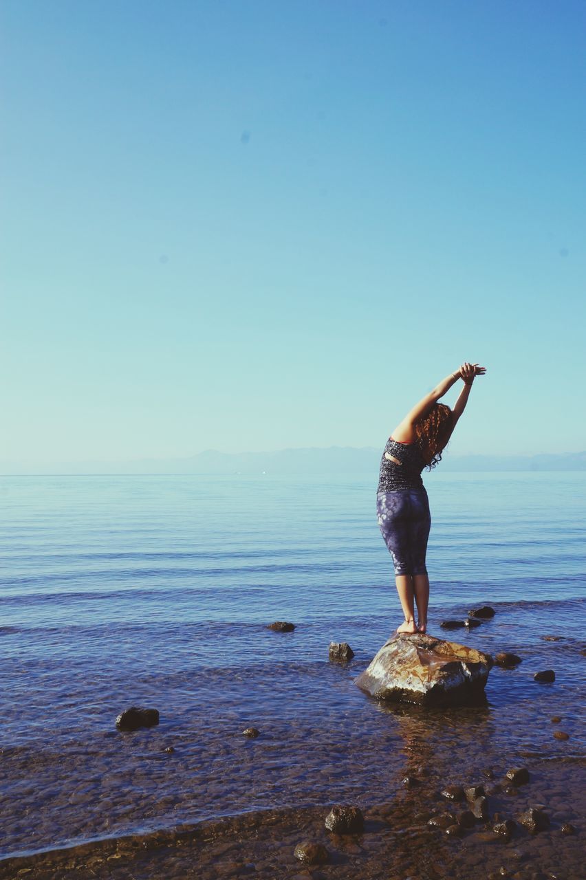 sea, water, full length, horizon over water, leisure activity, lifestyles, standing, copy space, beauty in nature, blue, tranquil scene, scenics, rear view, tranquility, nature, beach, sky, clear sky