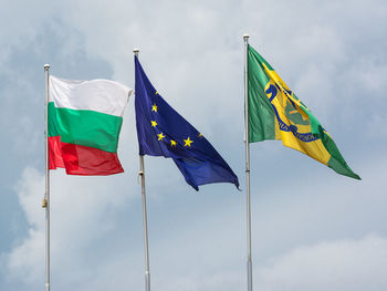 Low angle view of flag flags against sky