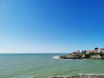 Scenic view of sea against clear blue sky
