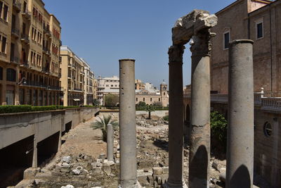 Old columns  in city against clear sky