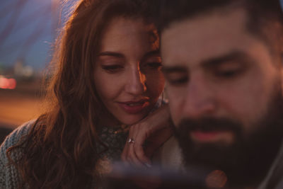 Hipster man showing smart phone to girlfriend