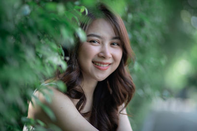 Portrait of smiling woman by plants