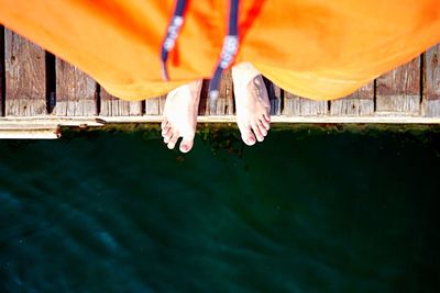 Low section of man sitting in water