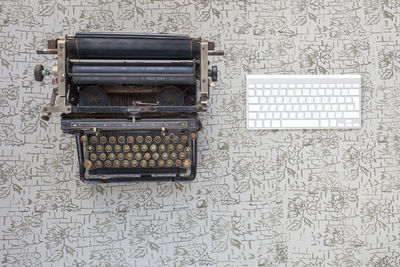 Directly above shot of old typewriter by computer keyboard on table