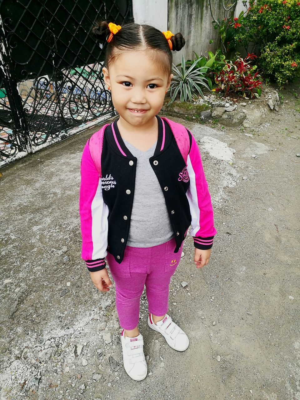 PORTRAIT OF SMILING GIRL WITH PINK PETALS