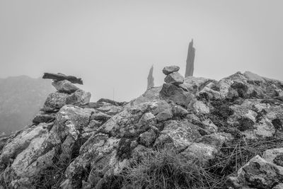 Low angle view of rocks on mountain against clear sky
