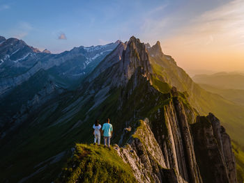 Rear view of people on mountain against sky