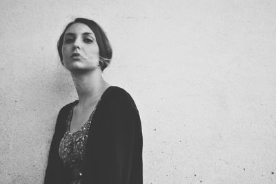 Young woman standing against wall