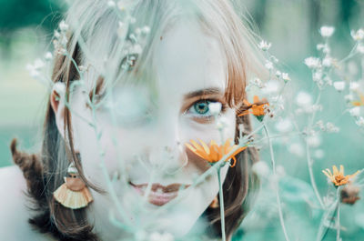 Close-up of beautiful woman looking through plants