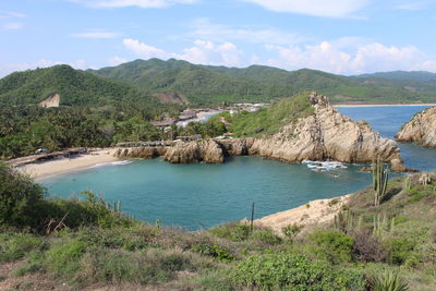 Scenic view of sea and mountains against sky