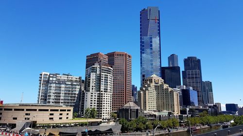 Low angle view of skyscrapers against blue sky