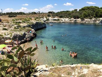 High angle view of people on rock by sea