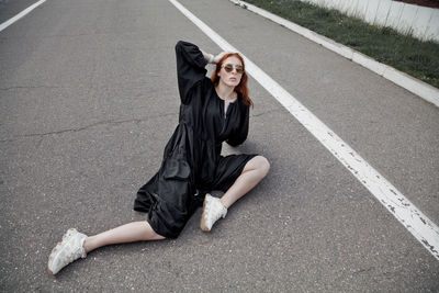 Portrait of a smiling young woman on road in city