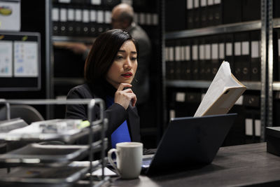 Young woman using laptop while sitting at cafe