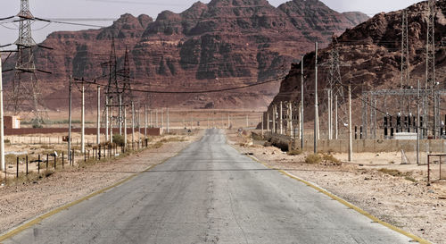 Road by mountain against sky